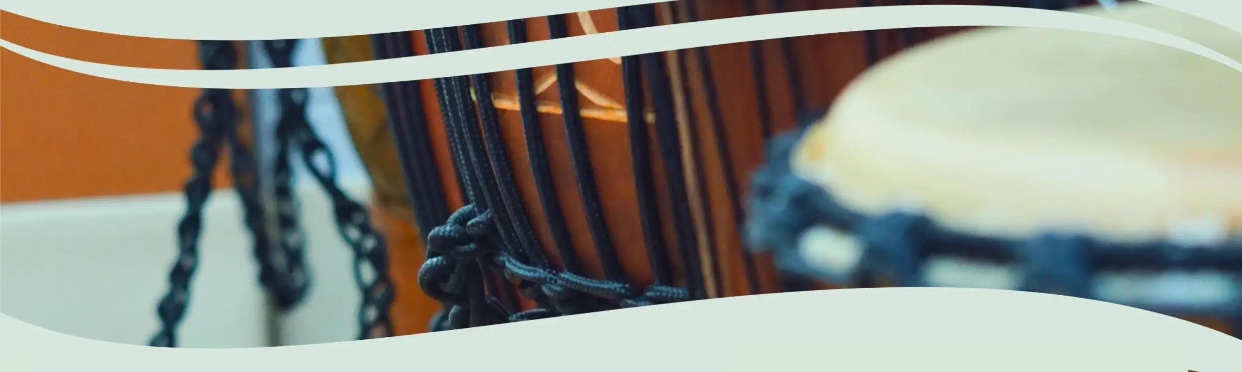 Black braided chain attached to a drum with orange and black tones