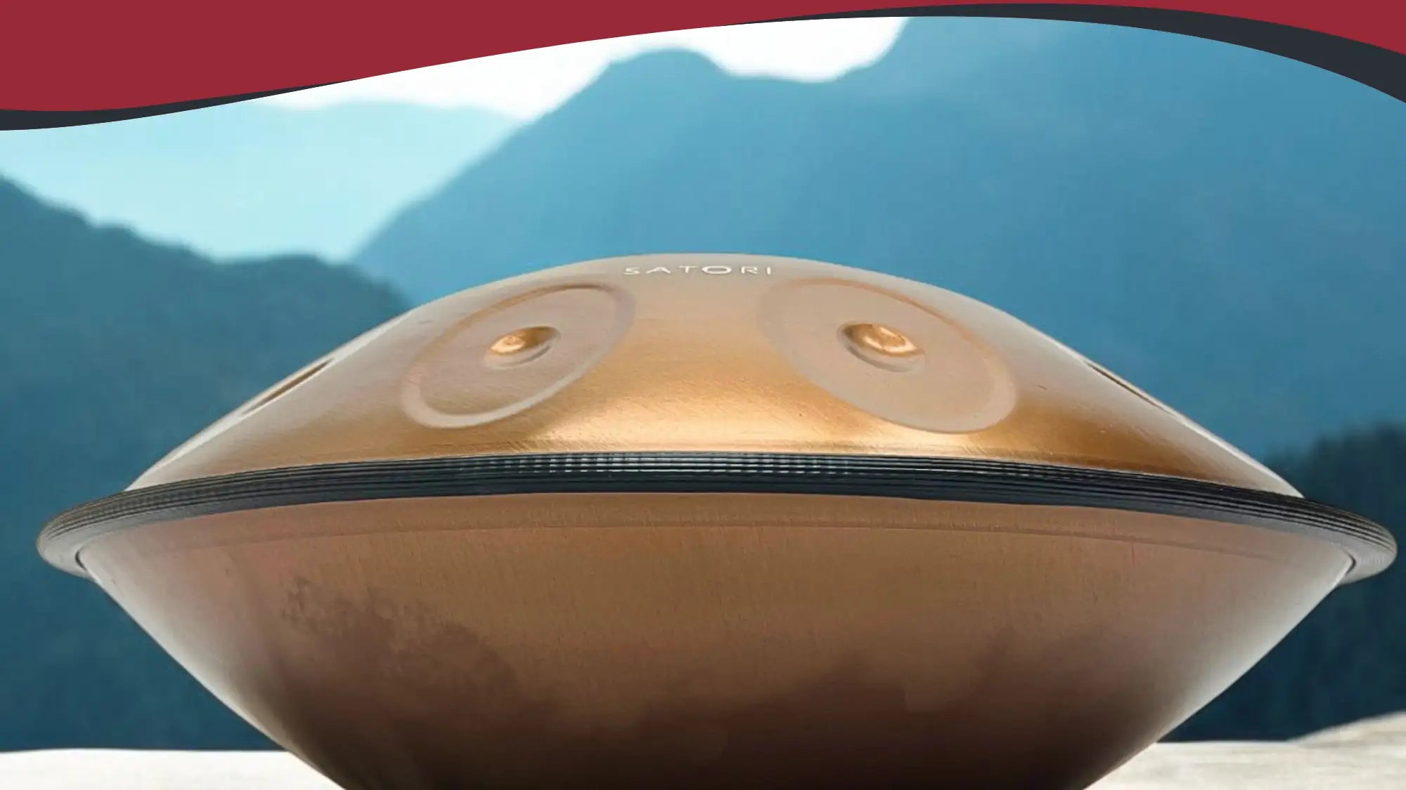 Golden satori handpan with a smooth, reflective surface and two circular sound holes.