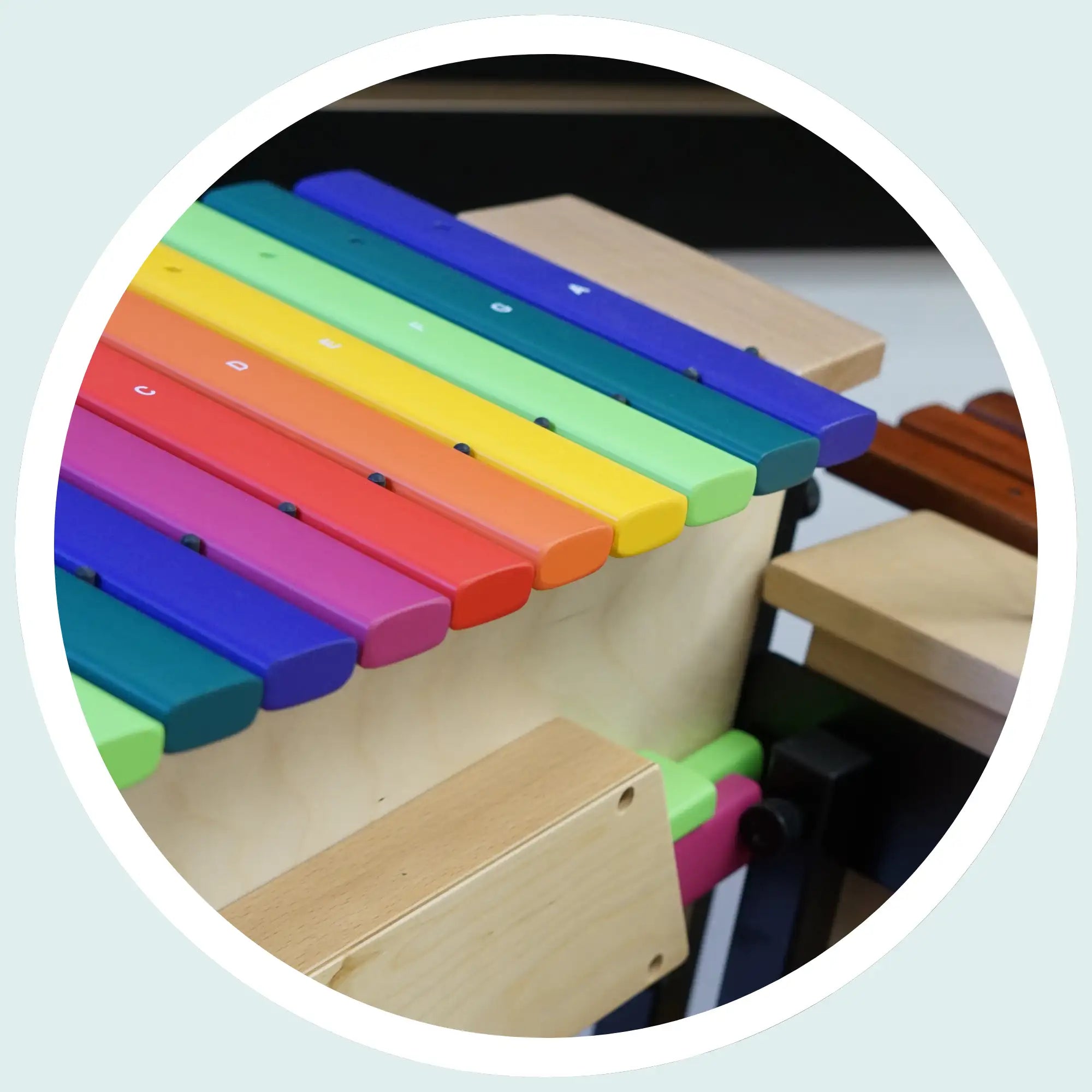 Rainbow-colored wooden xylophone with vibrant, painted bars arranged in a musical scale.