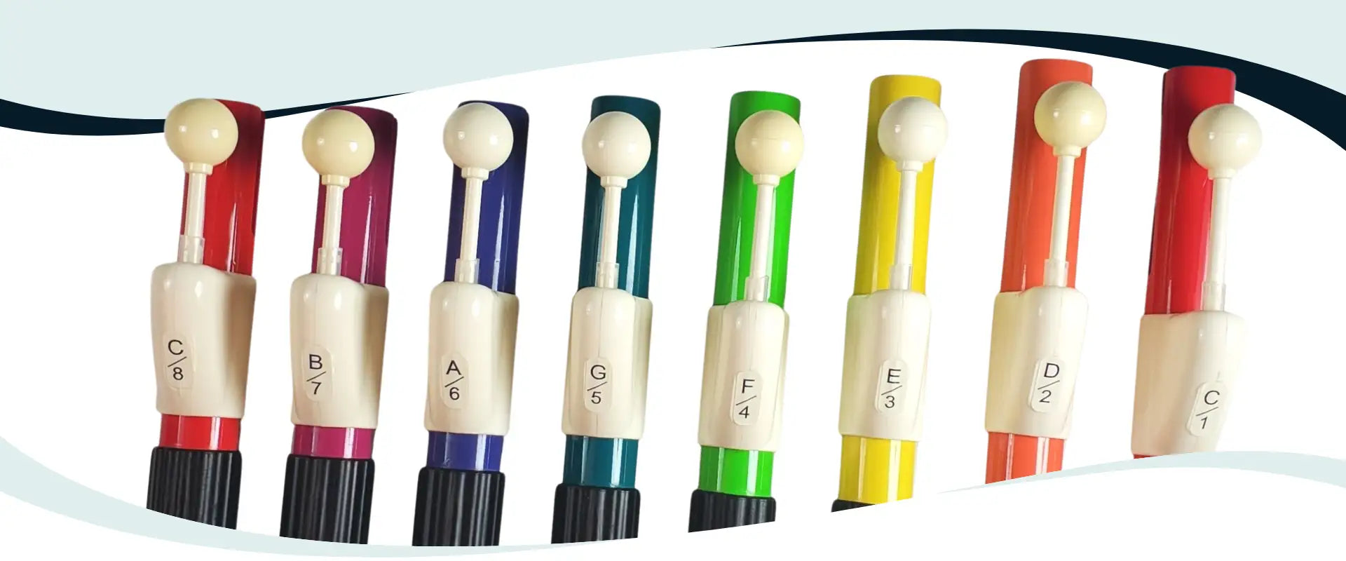 A set of colorful, plastic-tipped flute keys with white spherical tops and labeled note indicators.