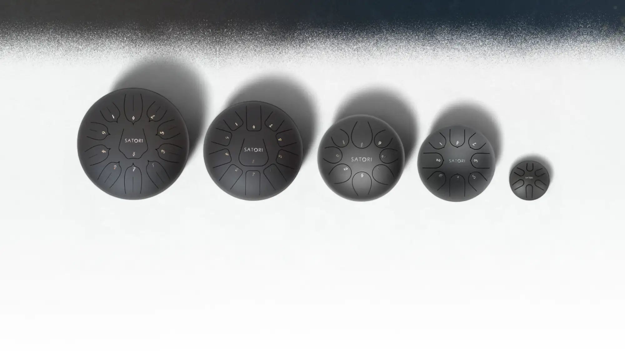 A set of five black satomi brand hand drums, each with a matte finish and numbered playing areas.