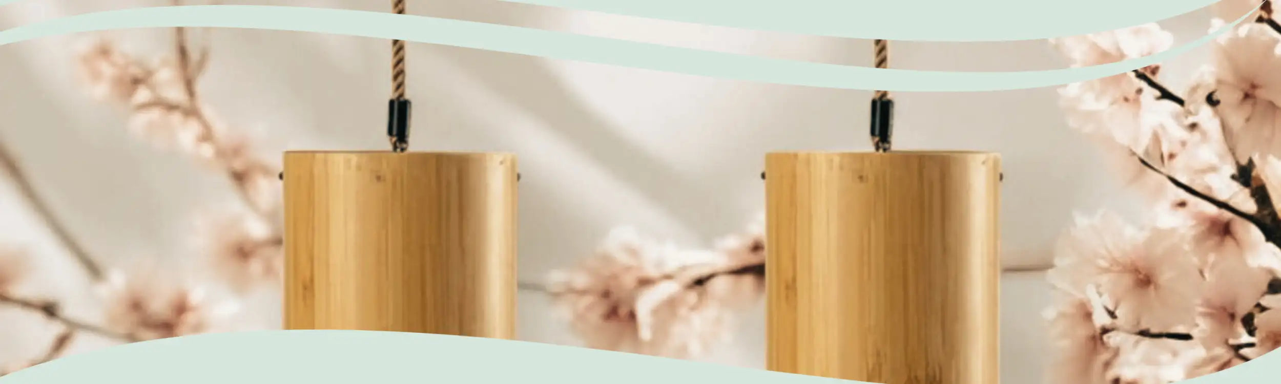 Two cylindrical bamboo pendant lights with natural wood grain and black metal suspension hardware.