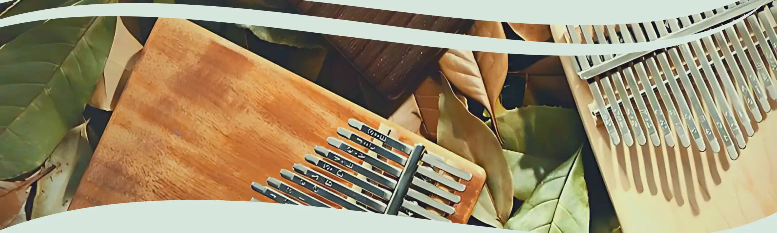 A wooden kalimba with silver-colored metal tines resting on a natural wood surface.