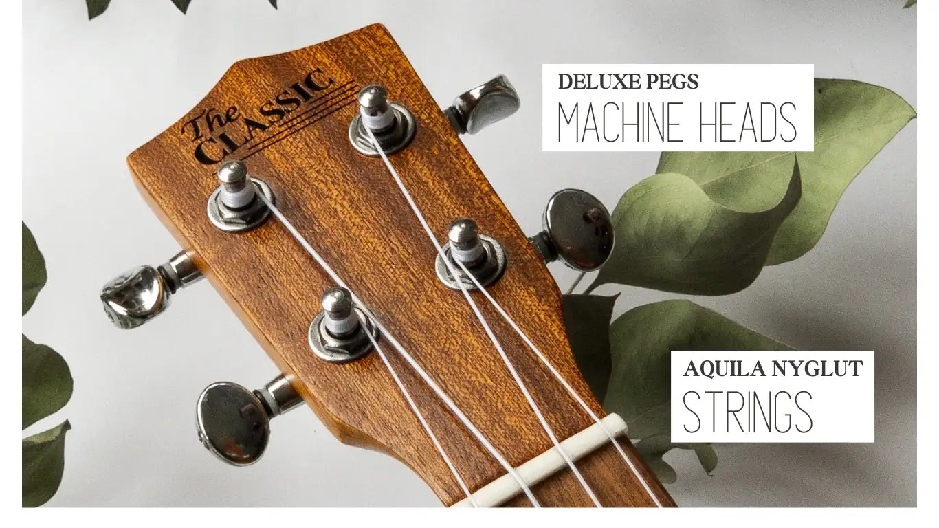 Wooden ukulele headstock with ’the classic’ engraved, featuring silver machine heads and white strings.