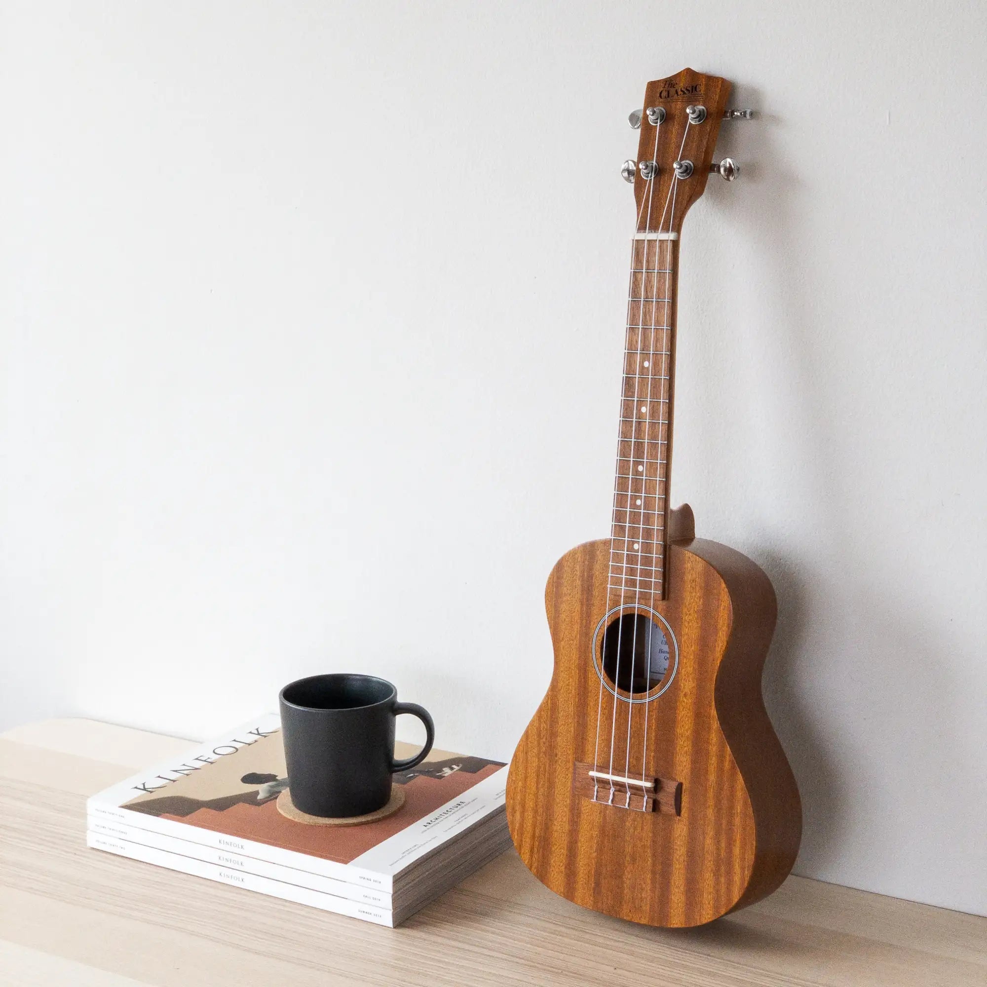 A wooden ukulele with a warm, natural finish and silver tuning pegs.